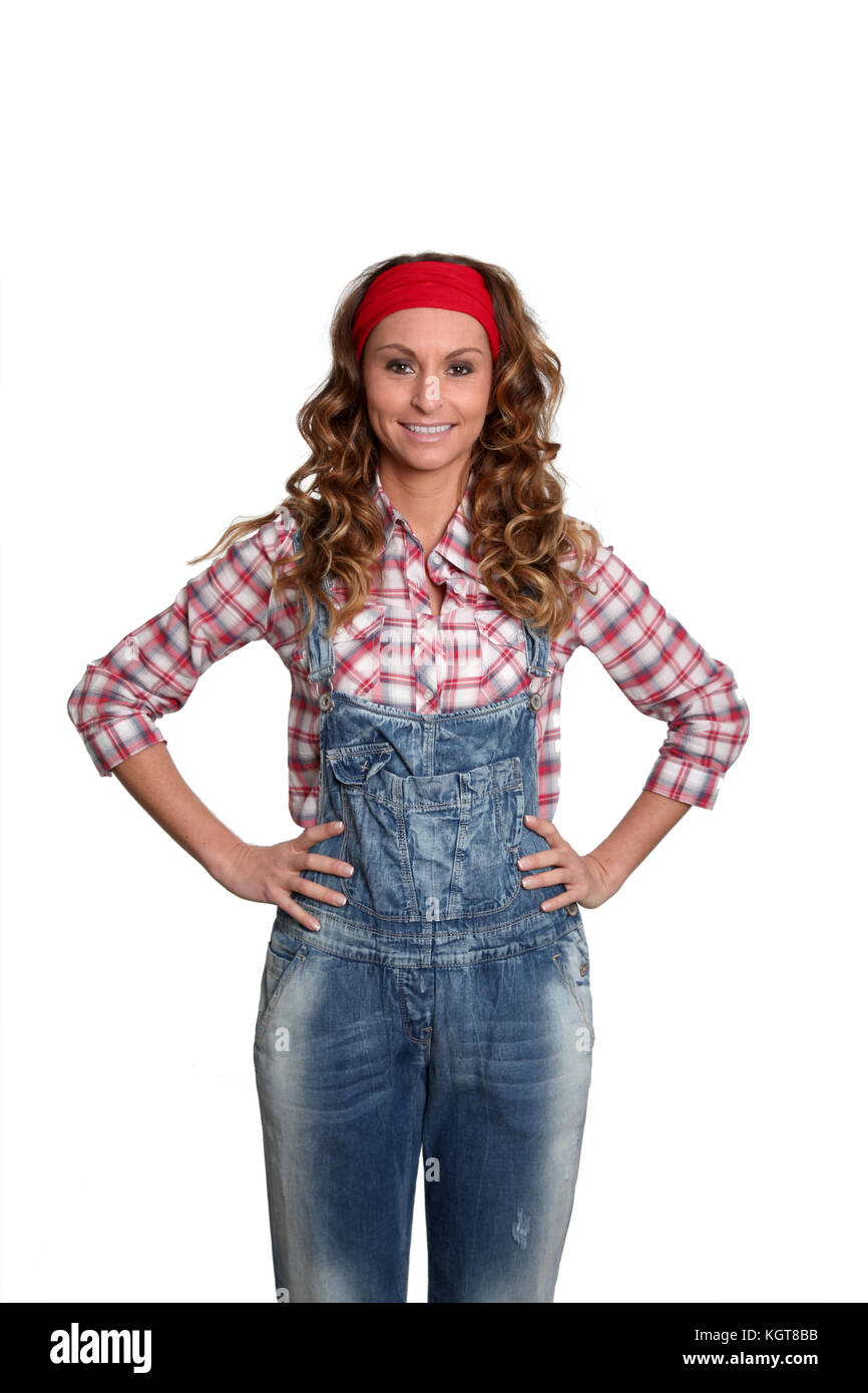 Woman with blue jeans overalls standing on white background Stock Photo -  Alamy