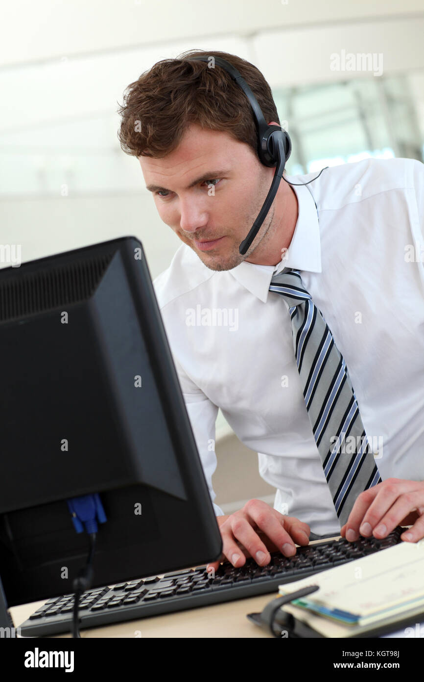 Customer service representative sitting in front of desktop Stock Photo