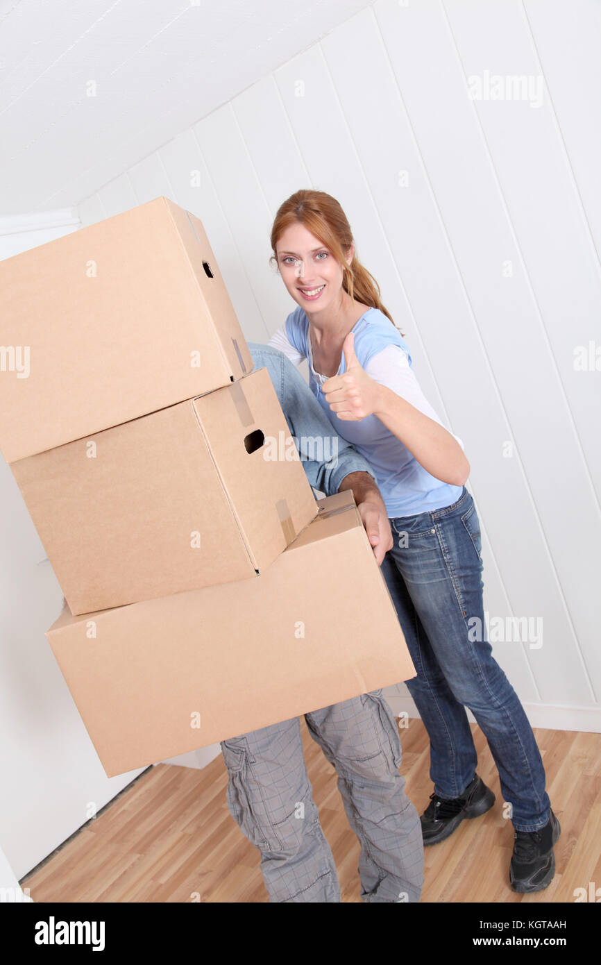 Couple carrying boxes to move in new house Stock Photo - Alamy