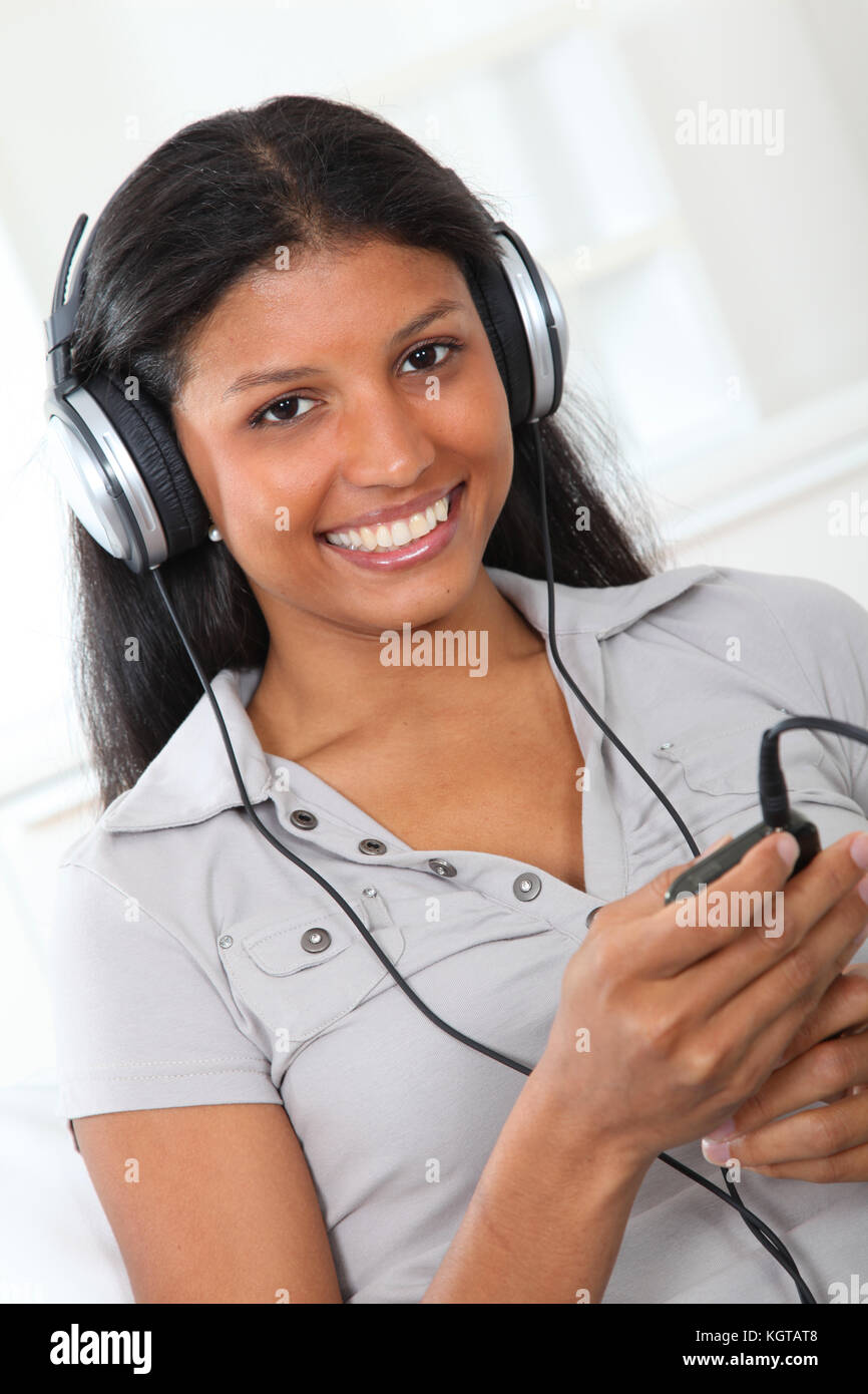 Beautiful latin girl listening to music with headphones Stock Photo - Alamy