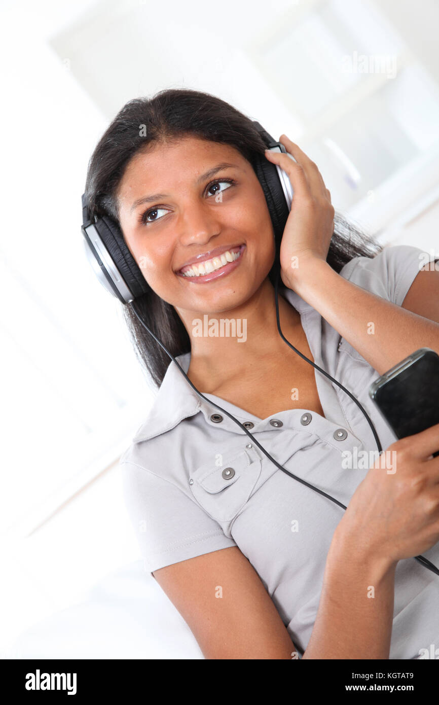 Beautiful latin girl listening to music with headphones Stock Photo - Alamy