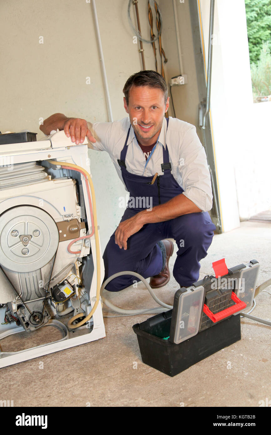 Plumber fixing washing machine Stock Photo Alamy