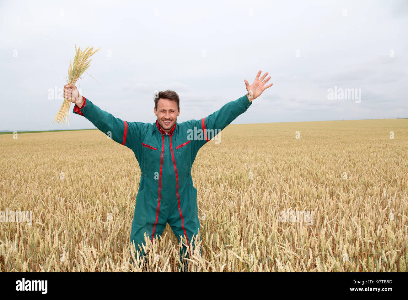Farmer standing in wheat field with arms up Stock Photo - Alamy