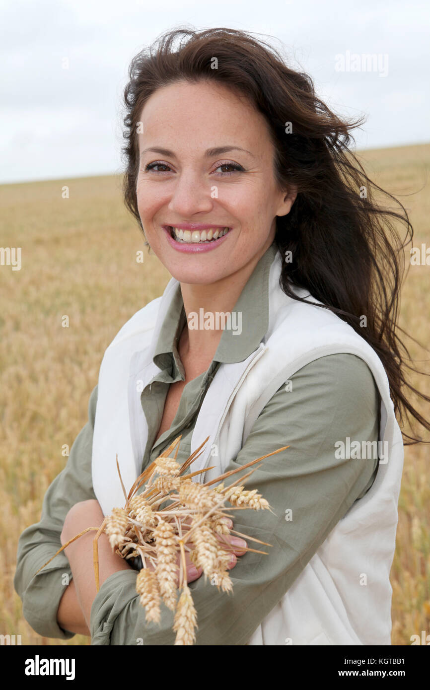 Beautiful woman standing in wheat field Stock Photo - Alamy
