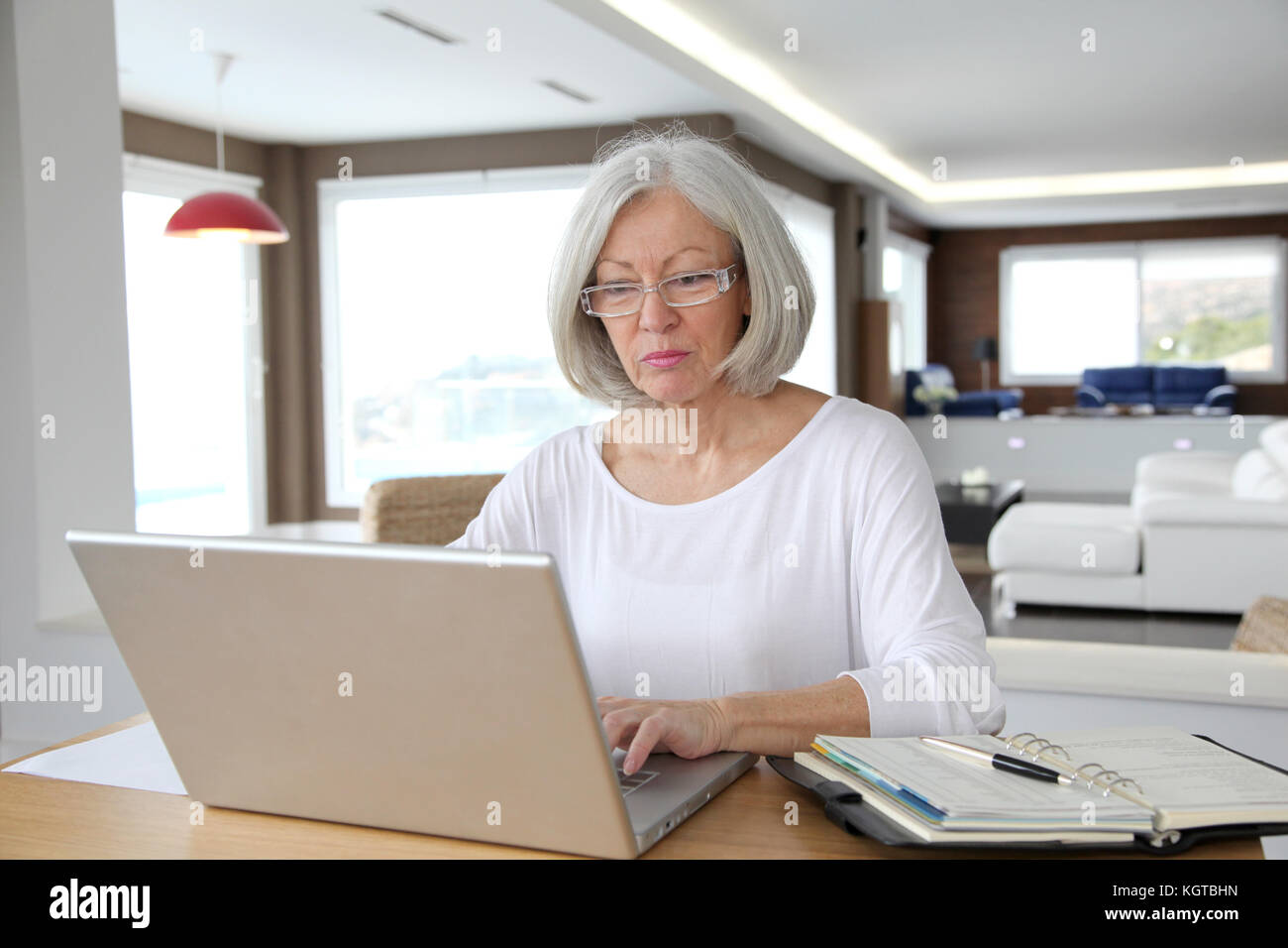 Senior woman at home in front of laptop computer Stock Photo - Alamy