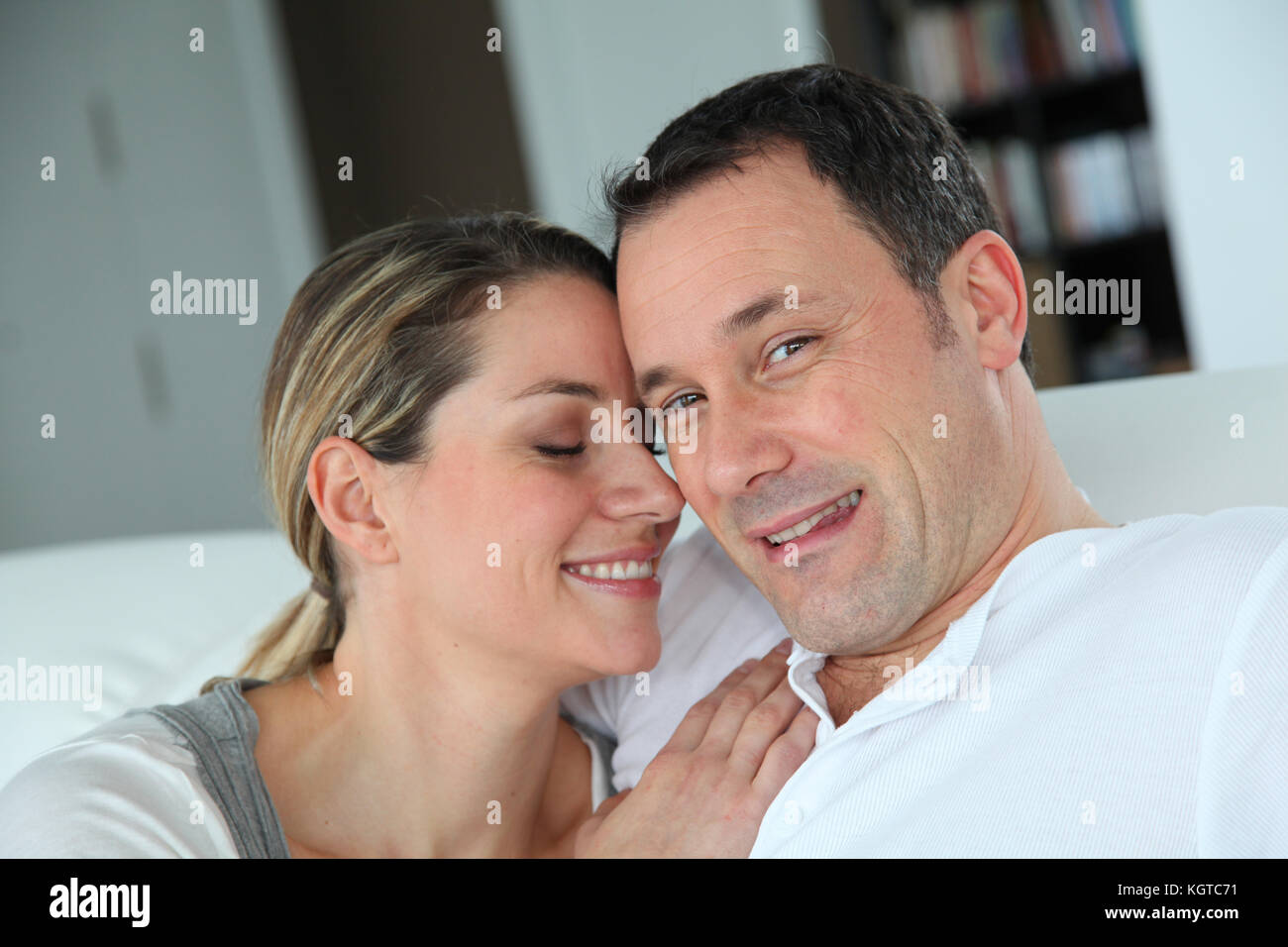 Portrait of couple relaxing at home in sofa Stock Photo - Alamy