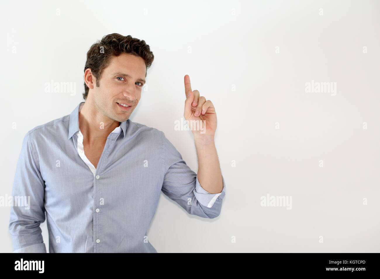 Young man pointing at message on white background Stock Photo