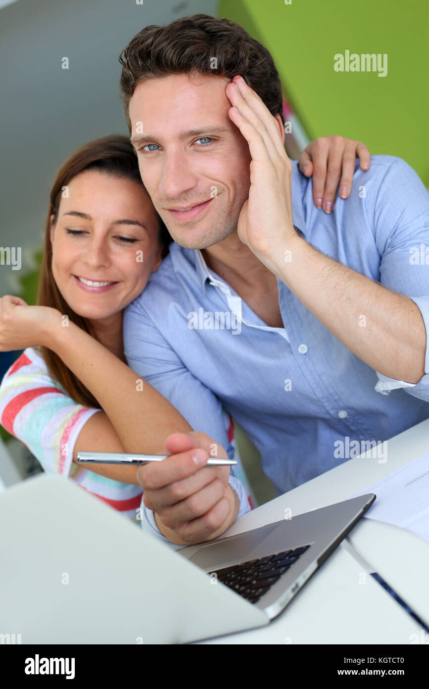 Couple at home sitting in front of laptop Stock Photo - Alamy