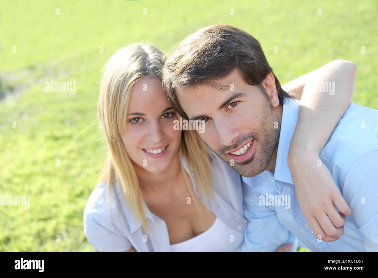 Happy young couple sitting in yard Stock Photo - Alamy