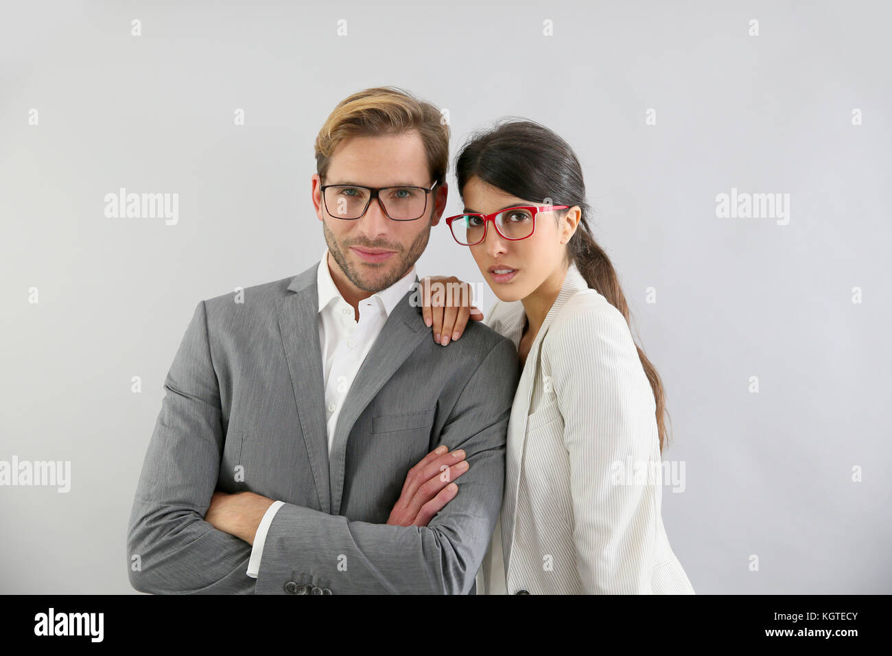 Business couple standing on grey background, isolated Stock Photo - Alamy