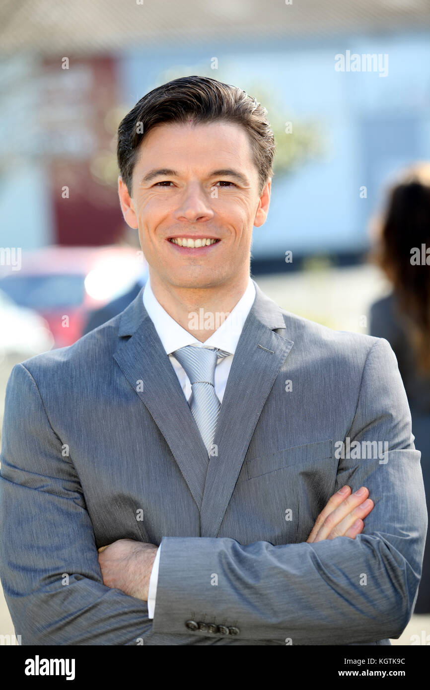 Portrait of businessman standing outside the office Stock Photo - Alamy
