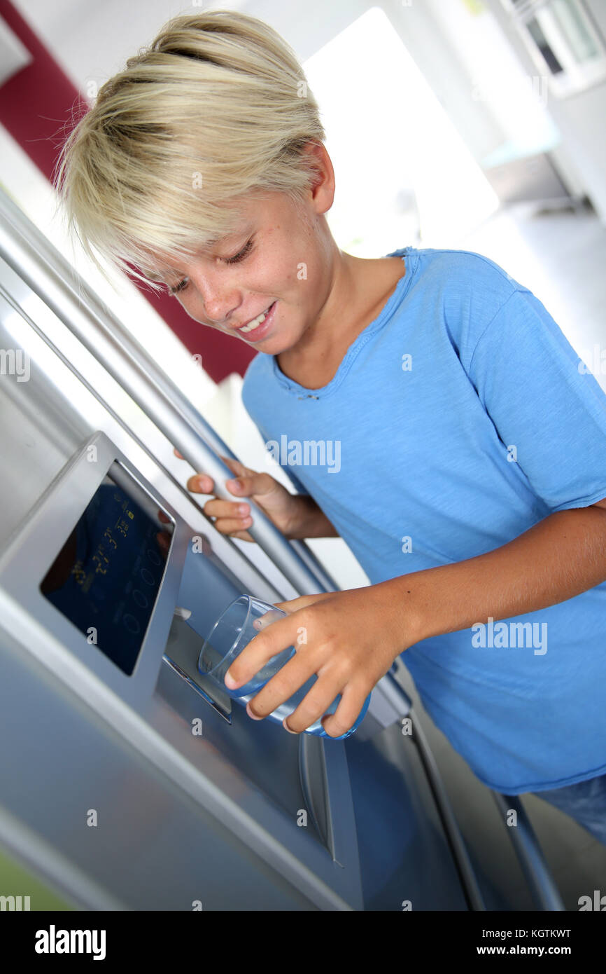 Young boy drinking water from fridge Stock Photo Alamy