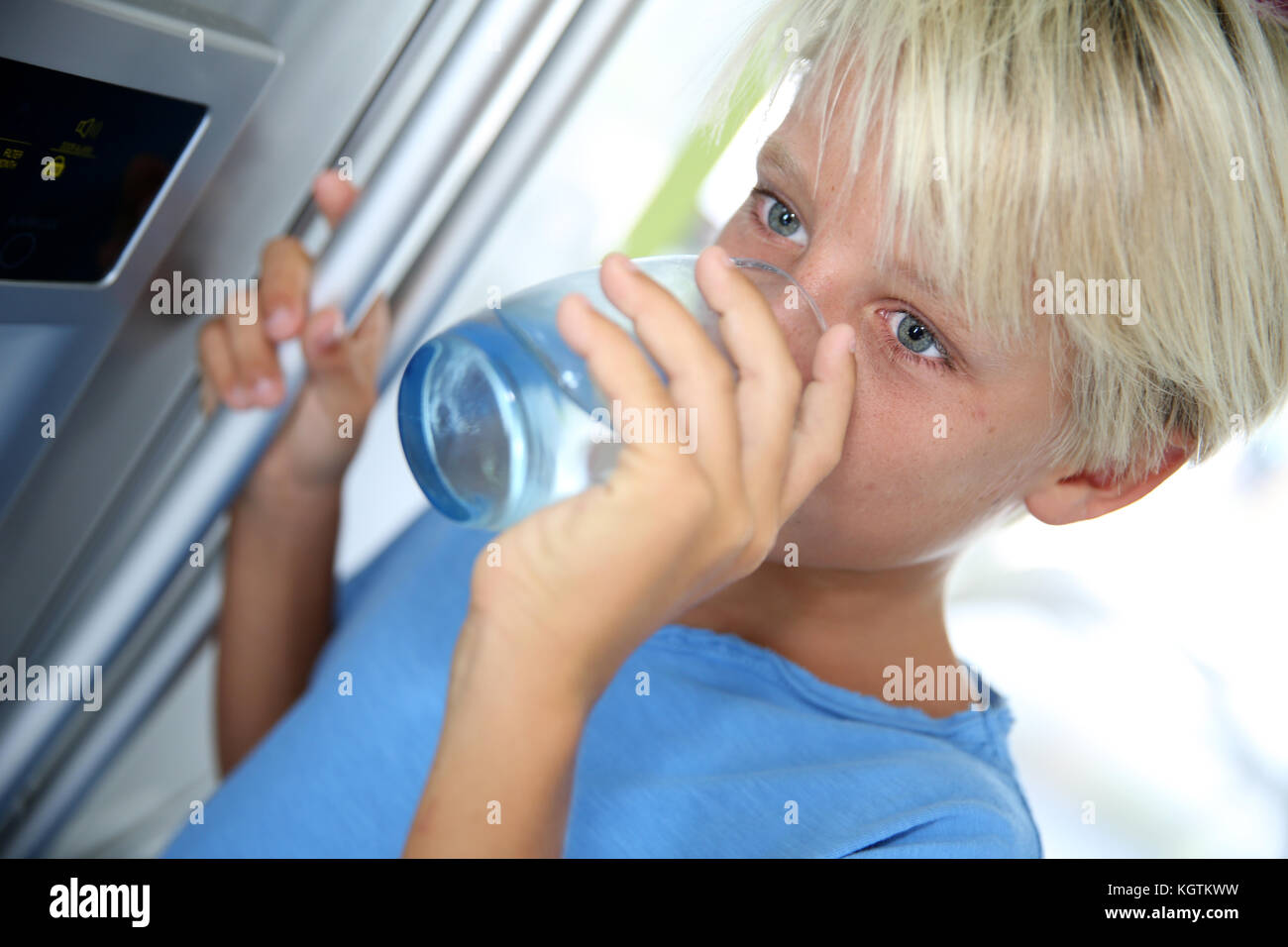 Young boy drinking water from fridge Stock Photo Alamy