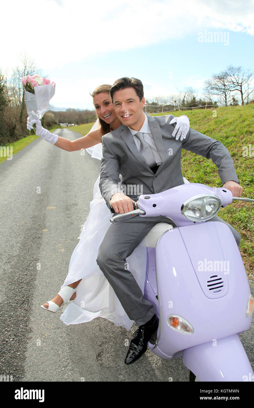 Married couple riding motorcycle on their wedding day Stock Photo