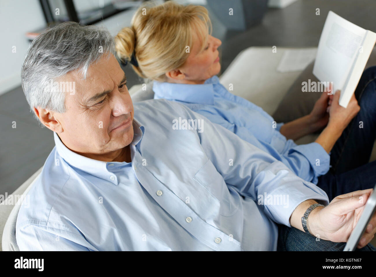 Senior couple relaxing at home in sofa Stock Photo - Alamy