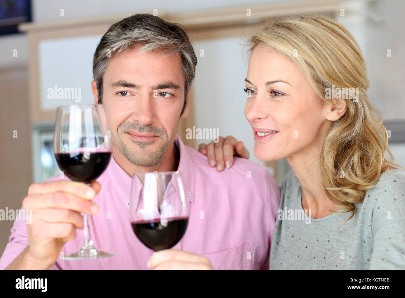 Couple drinking red wine in kitchen Stock Photo Alamy