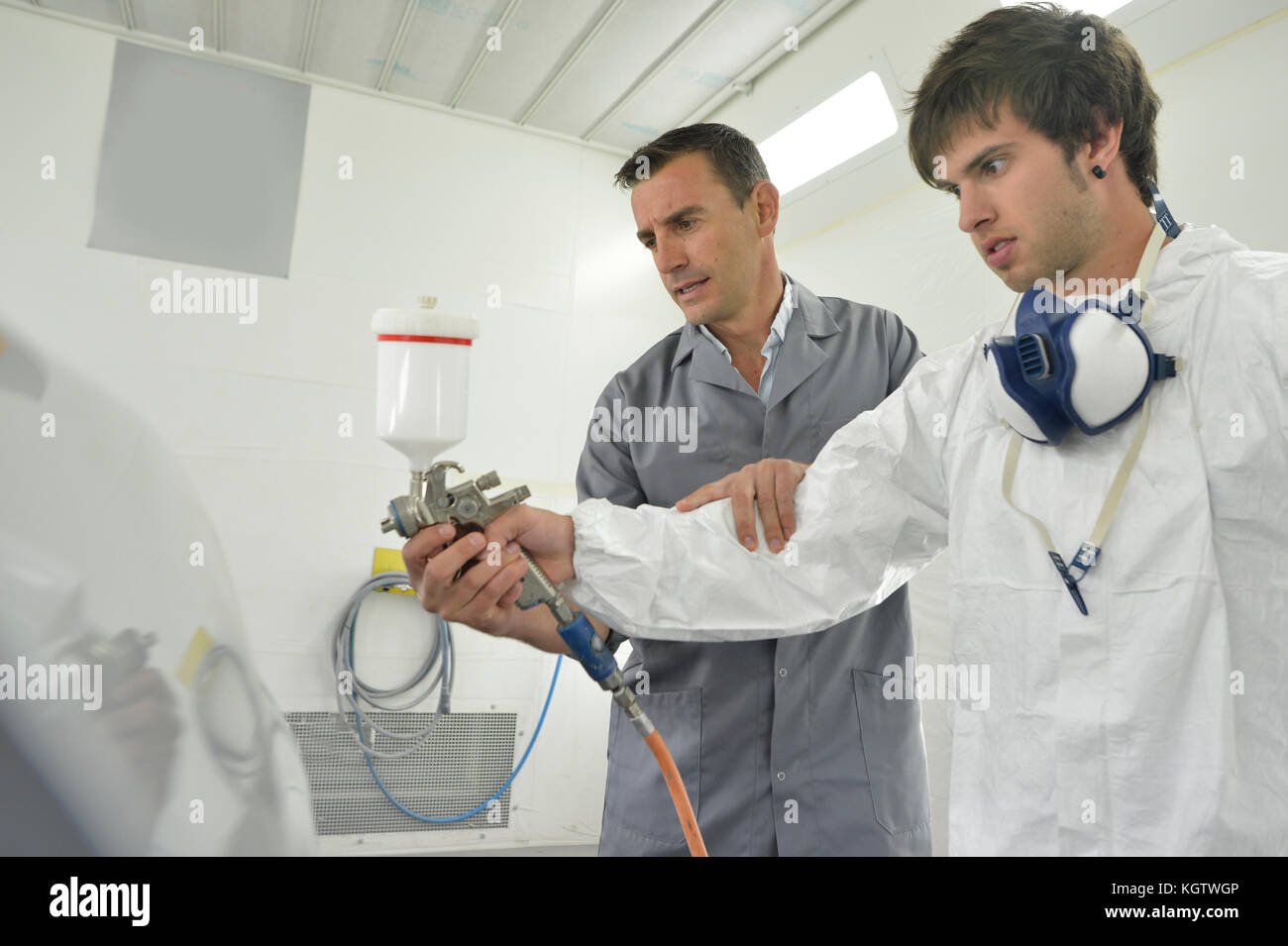 Instructor with teenager in car painting training class Stock Photo Alamy