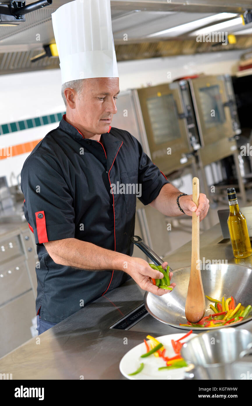 Chef in restaurant kitchen preparing wok of vegetables Stock Photo - Alamy