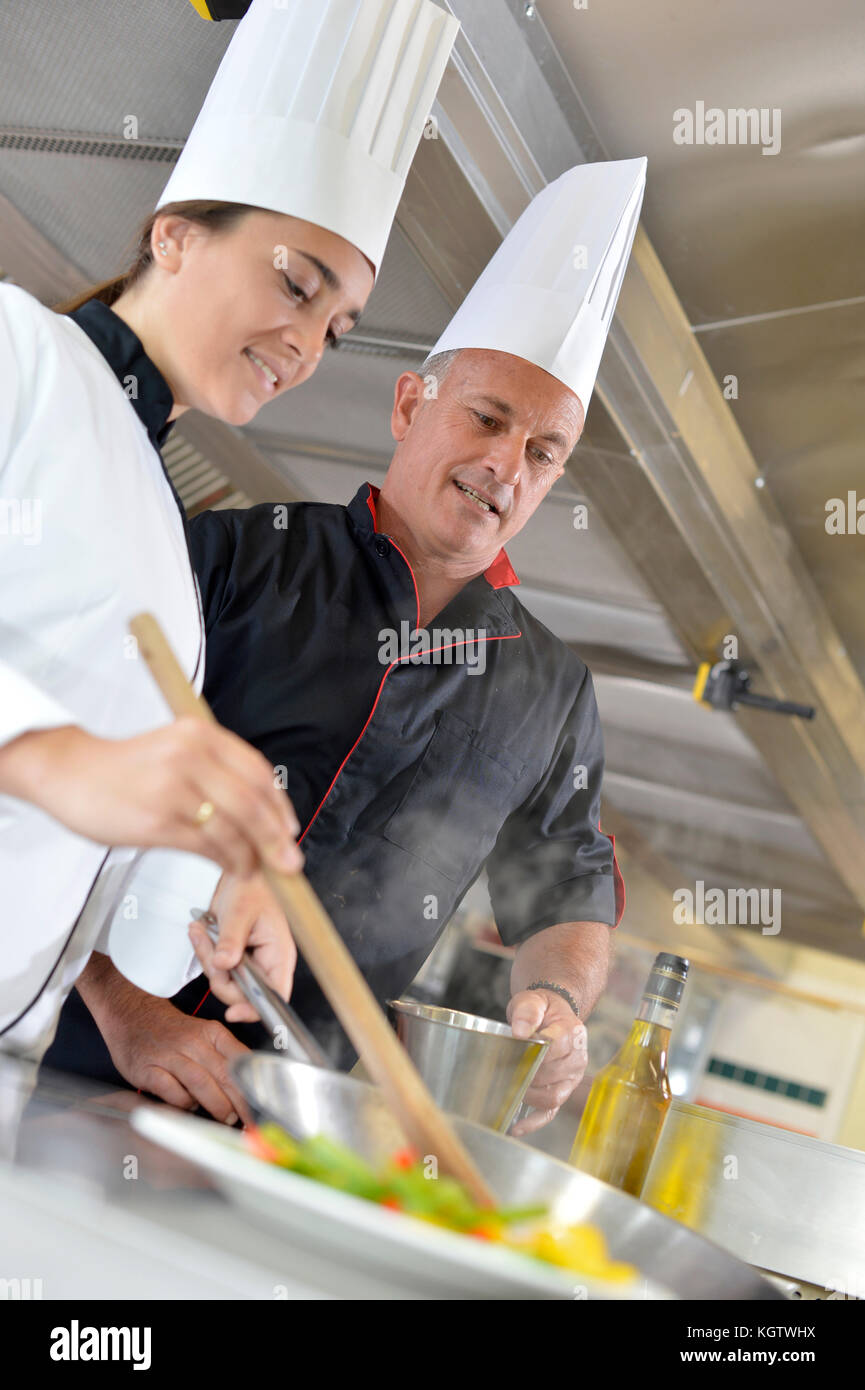 Chef teaching student how to prepare wok dish Stock Photo Alamy