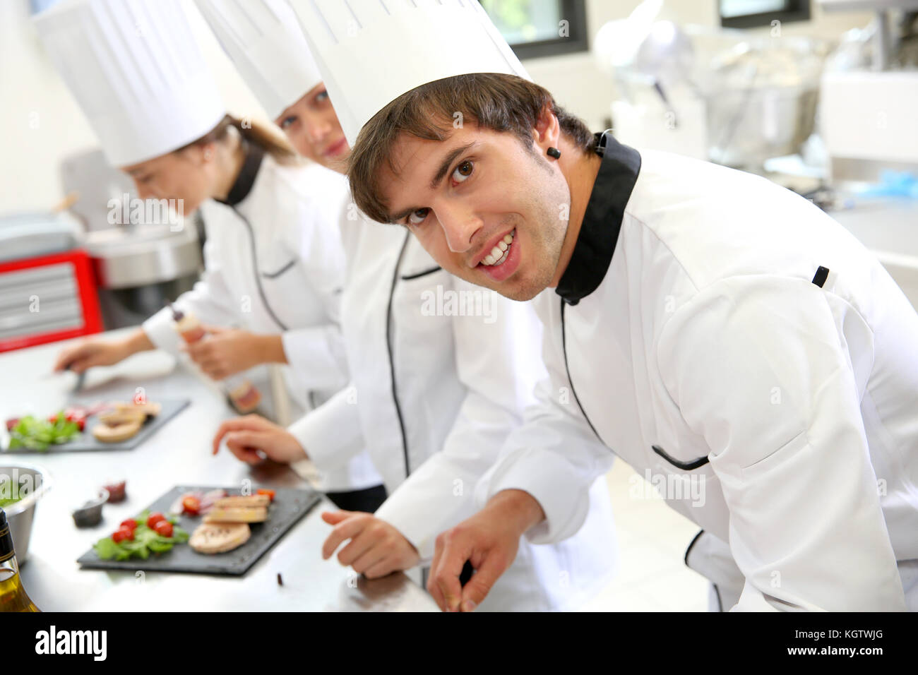 Smiling young man in restaurant kitchen Stock Photo
