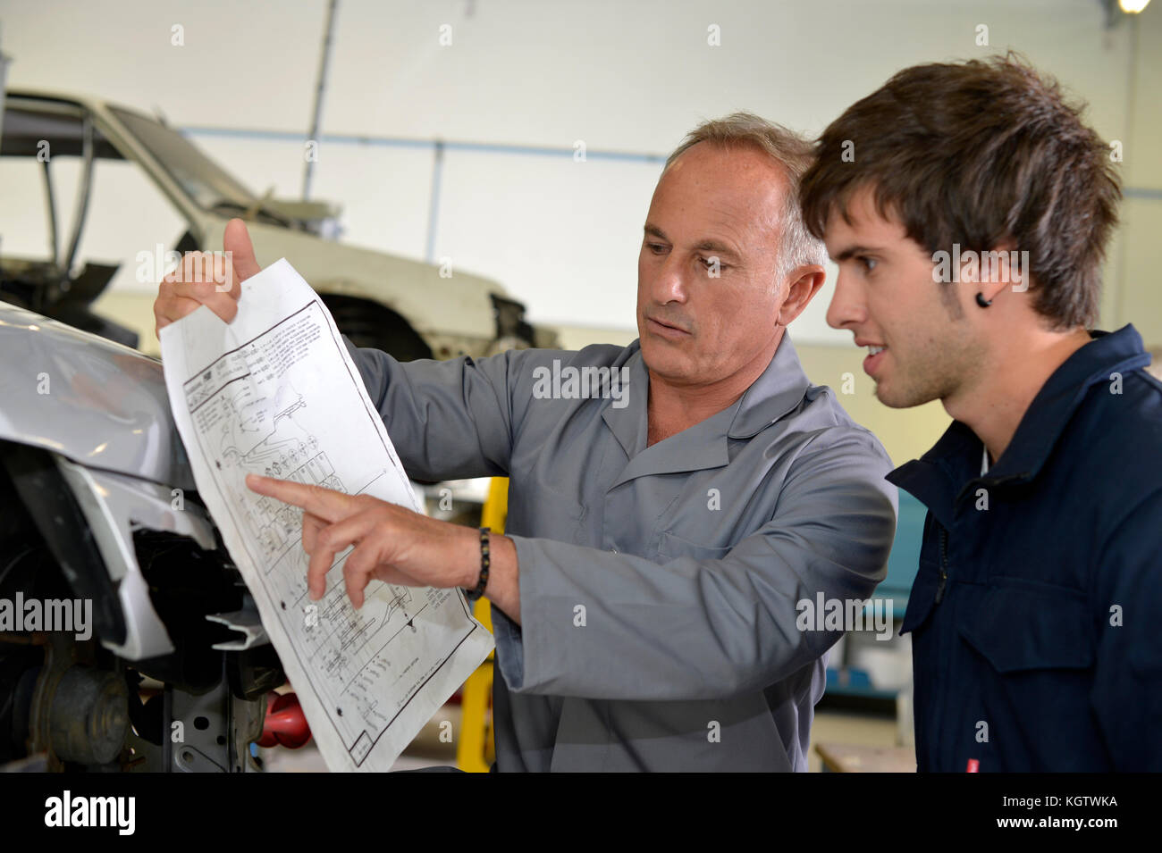 Teacher with coachbuidling student in repairshop Stock Photo