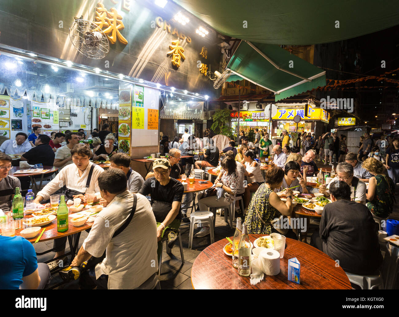 HONG KONG, CHINA - JUNE 16, 2017: Tourists and local dine in a restaurant in the streets of Kowloon near the famous Temple night market in Hong Kong. Stock Photo