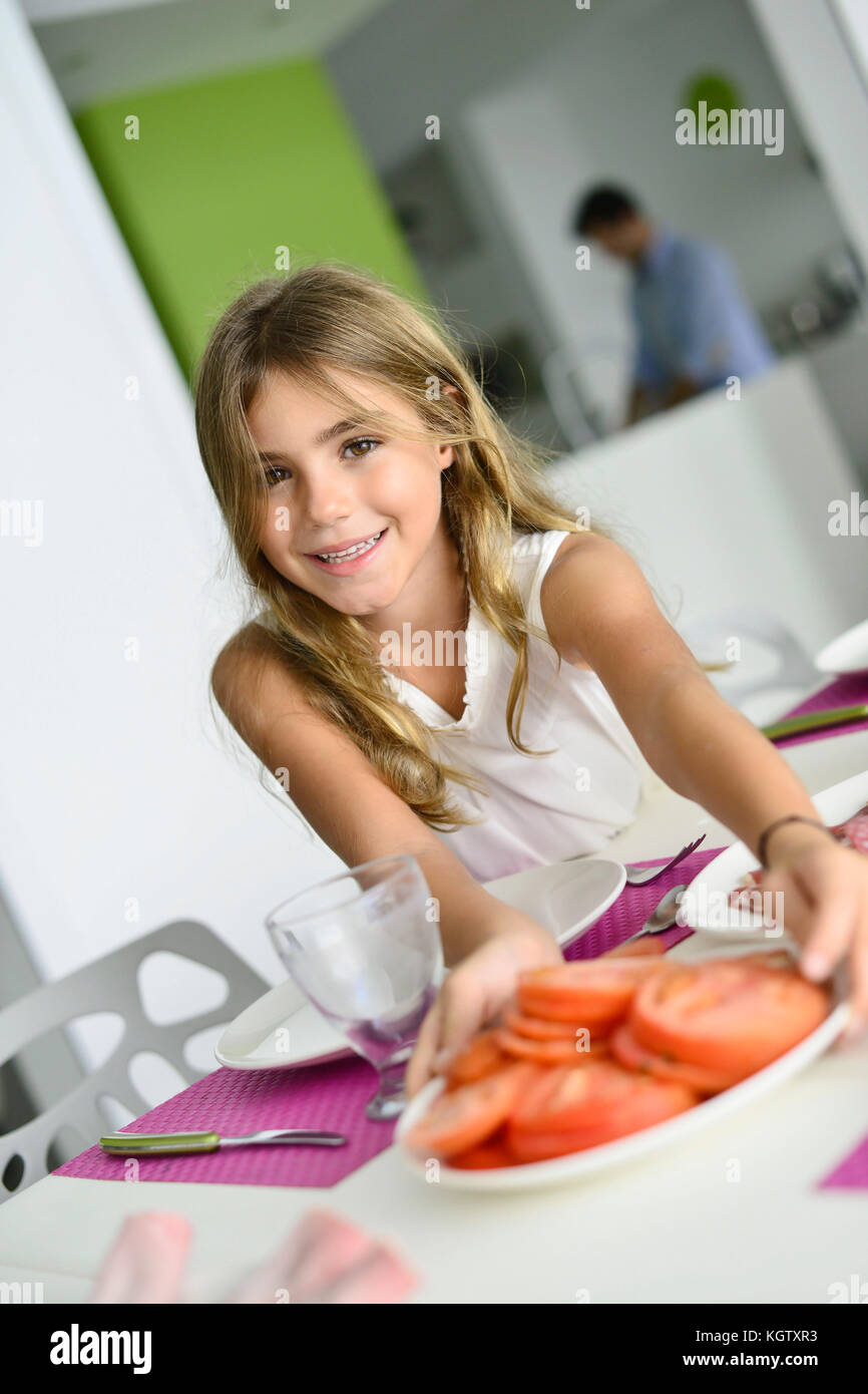 Little girl helping putting the table up for lunch Stock Photo