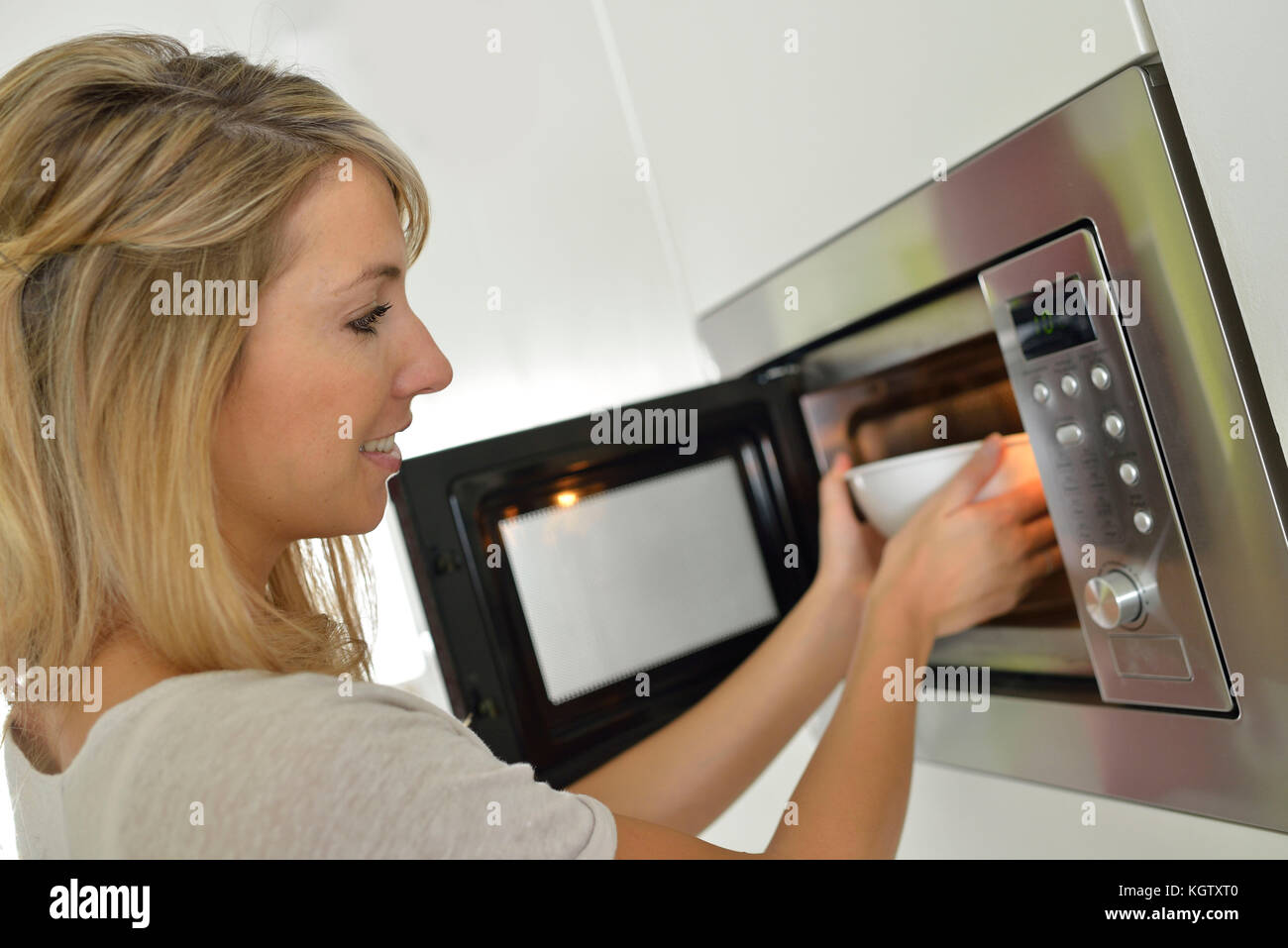 Woman at home using microwave oven Stock Photo Alamy