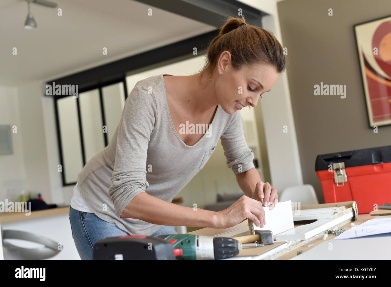 Woman at home assembling new furniture Stock Photo Alamy