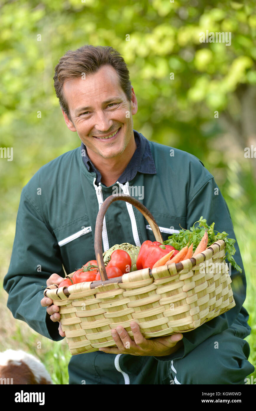 Farmer in garden holding basket of fresh vegetables Stock Photo - Alamy