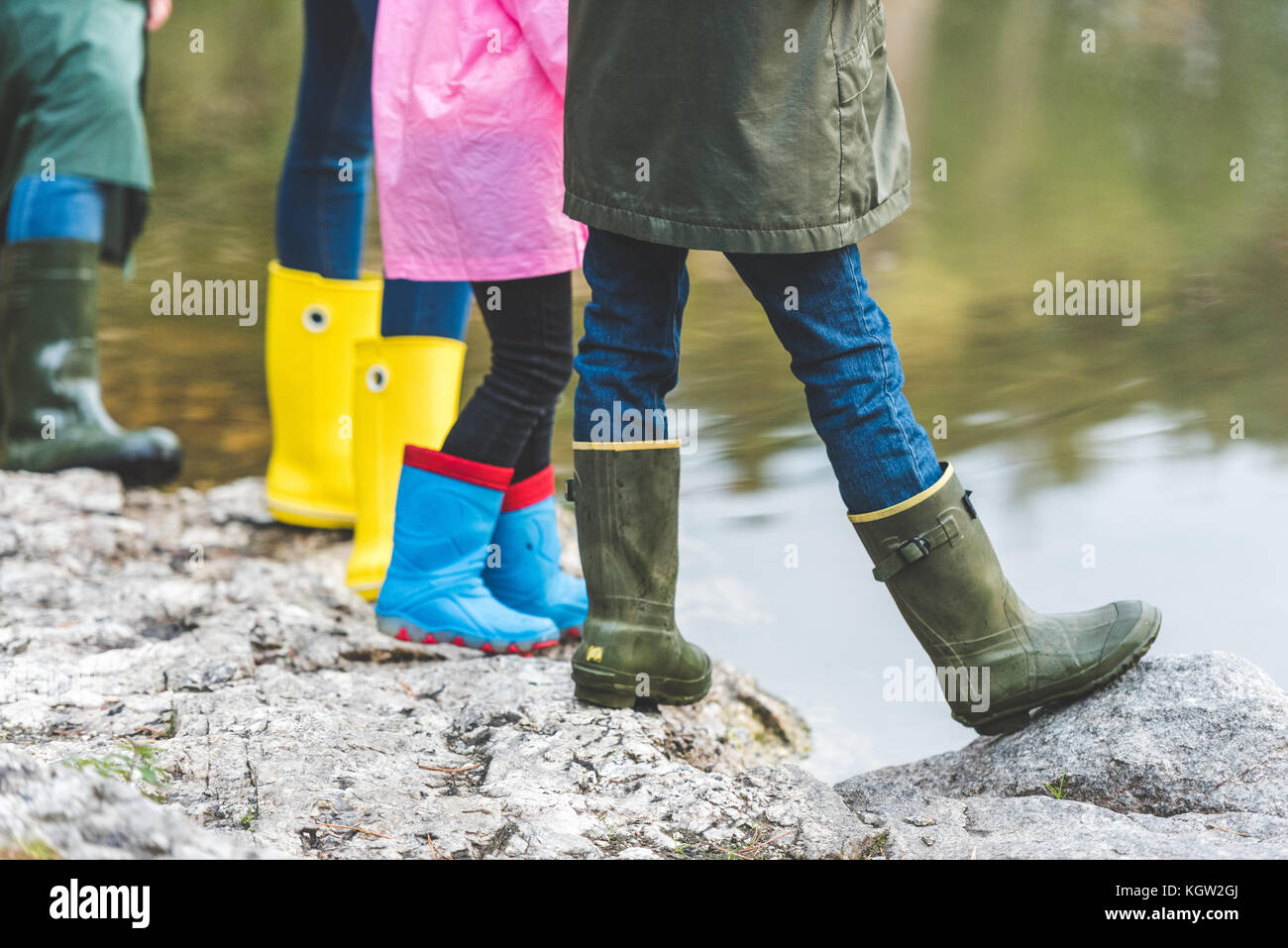 family in rubber boots standing on rock Stock Photo - Alamy
