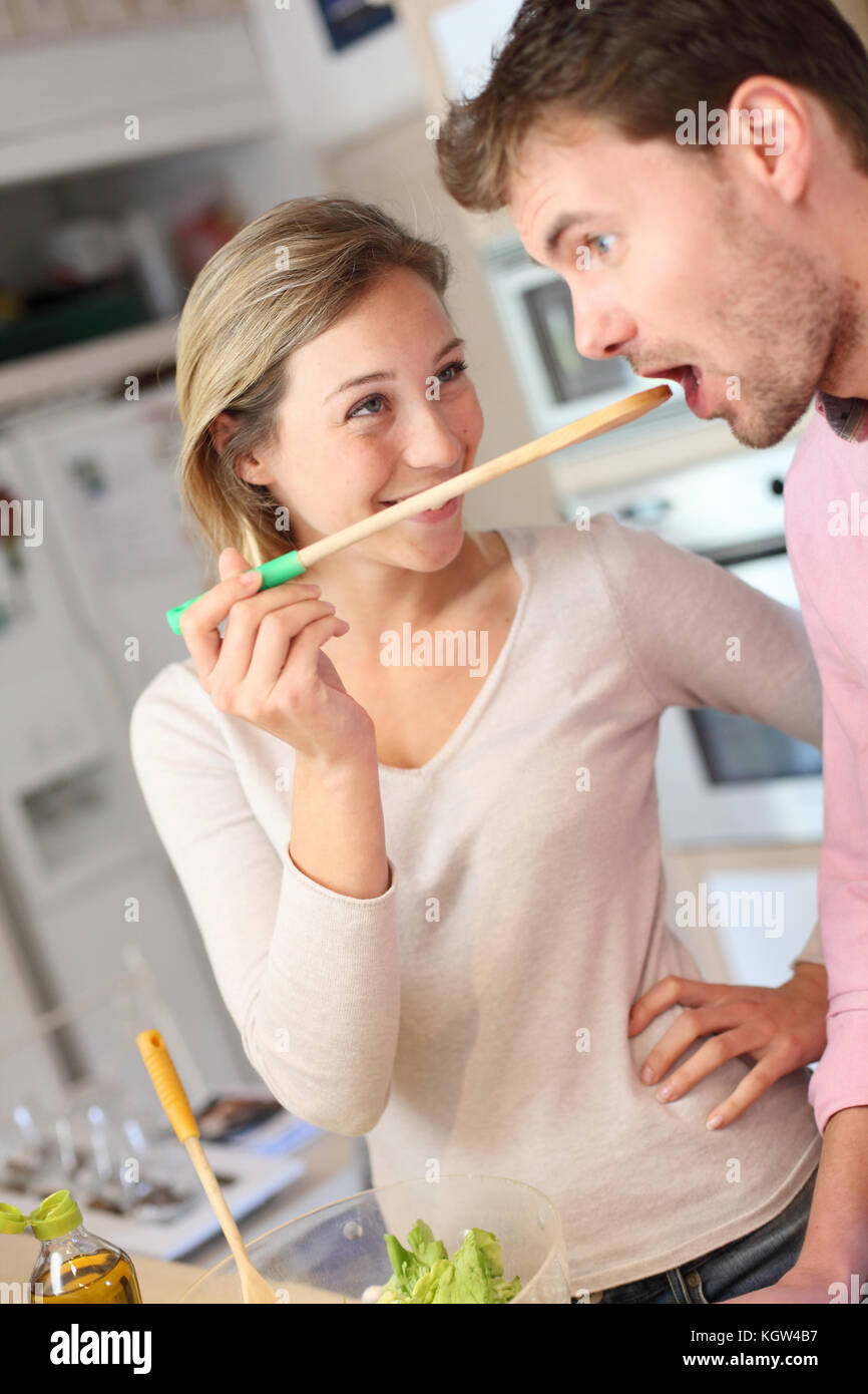 Couple enjoying preparing dinner in kitchen Stock Photo