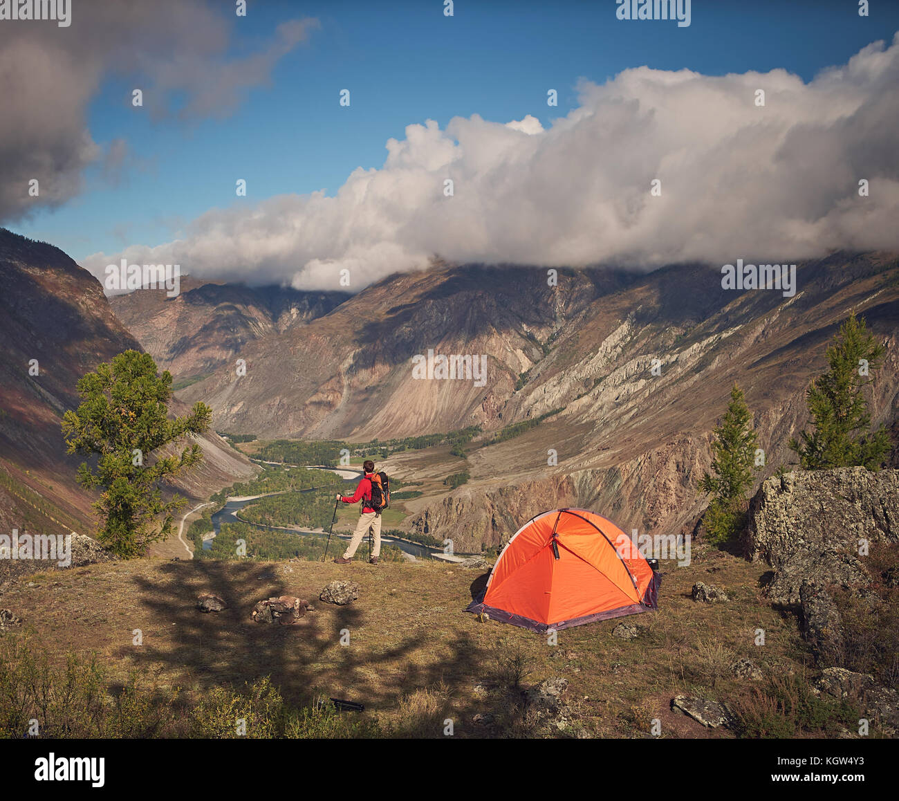 Person stands near the camping and look at the mountain valley Stock Photo