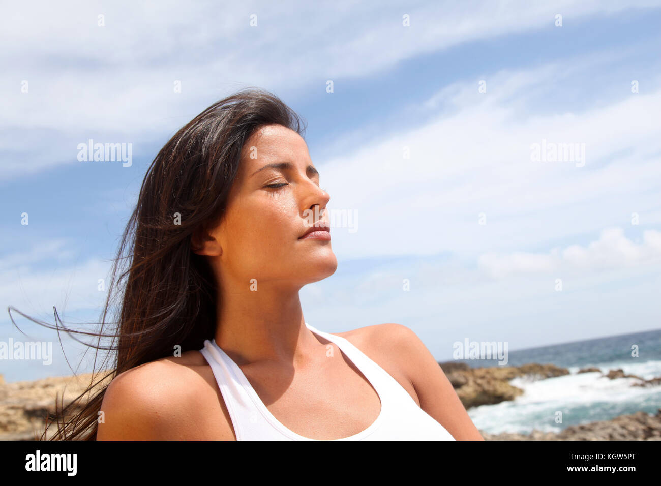 Woman sitting on rocks in fitness outfit Stock Photo - Alamy