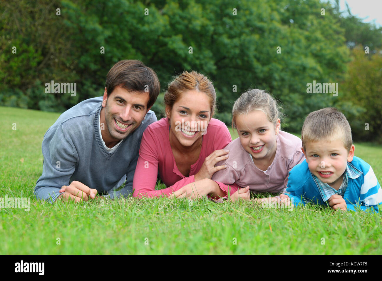 Portrait of happy family lying down in grass Stock Photo - Alamy