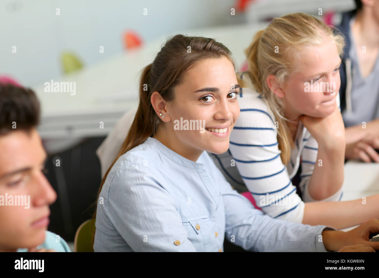 Portrait of cheerful student girl sitting in class Stock Photo - Alamy