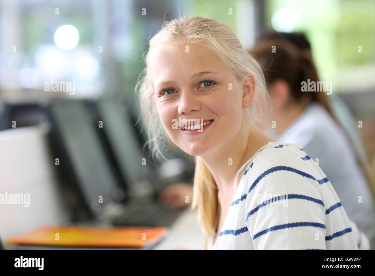 Portrait of cheerful student girl sitting in class Stock Photo - Alamy