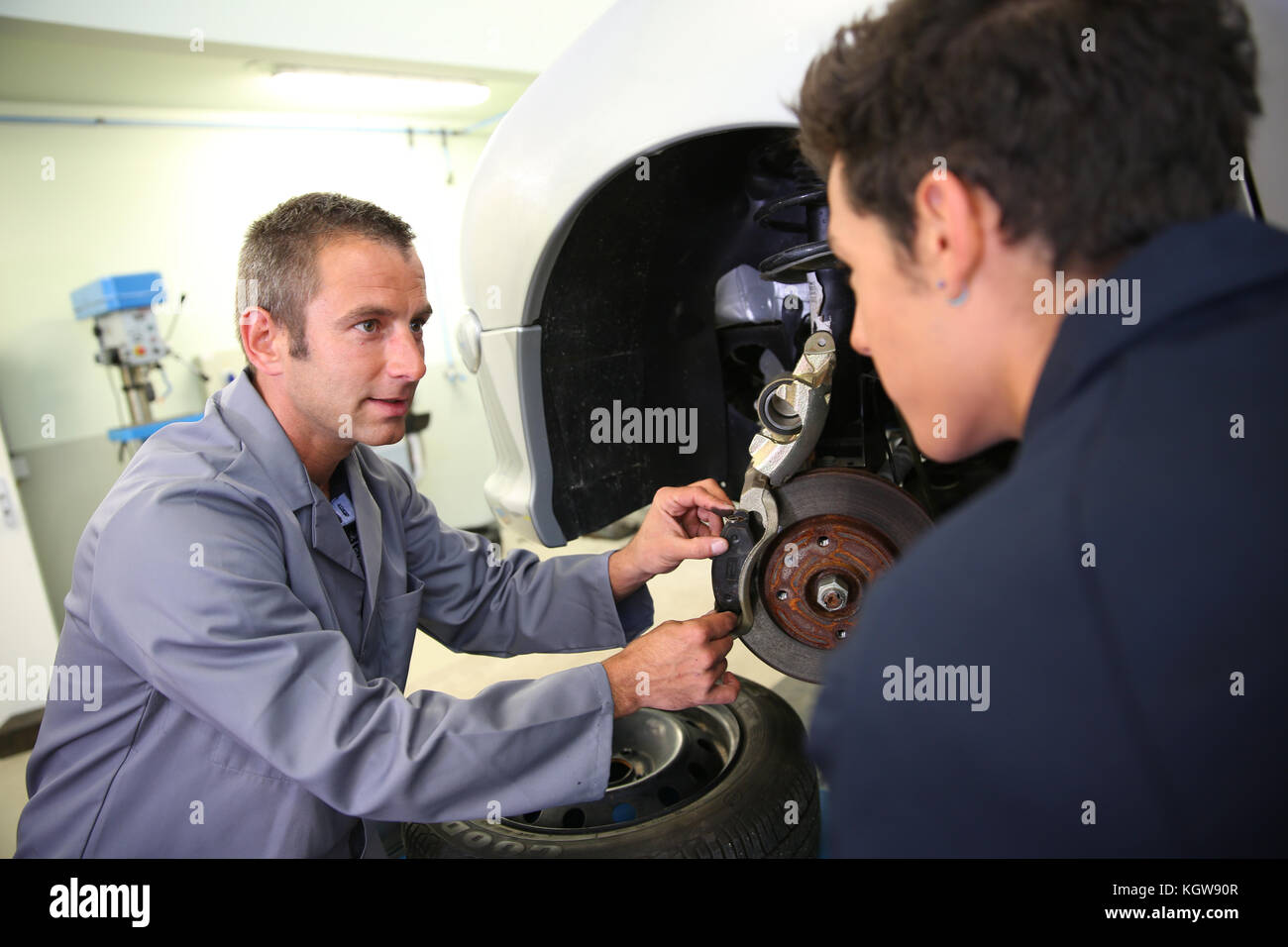 Instructor showing student how to change car brakes Stock Photo Alamy