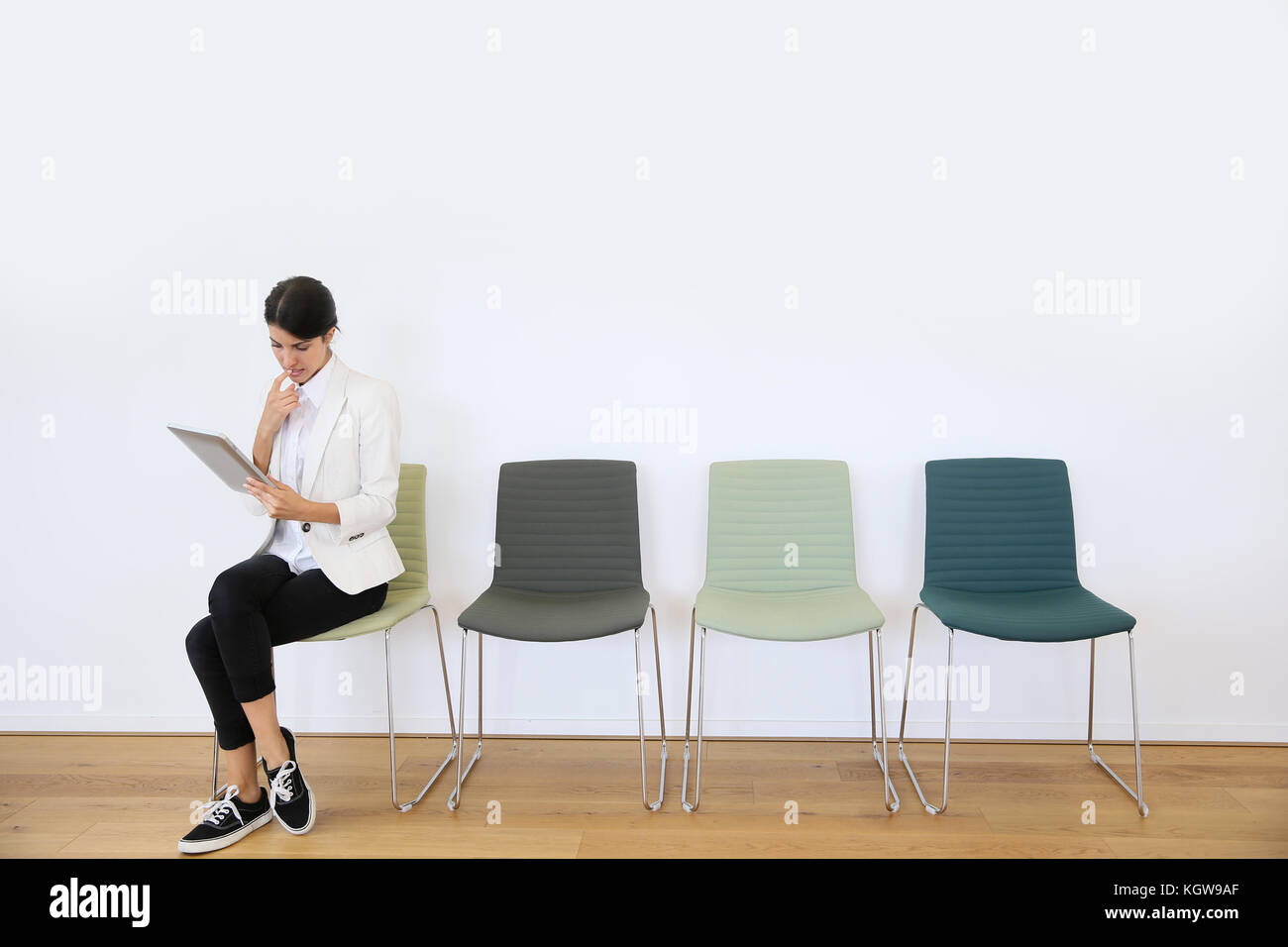 Woman in waiting room using digital tablet, concept Stock Photo