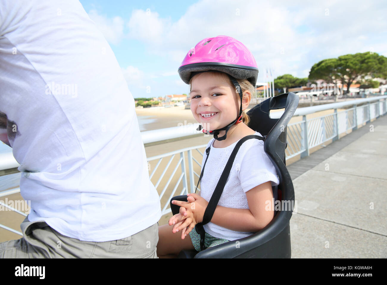 Smiling little girl sitting in child seat on bicycle Stock Photo Alamy