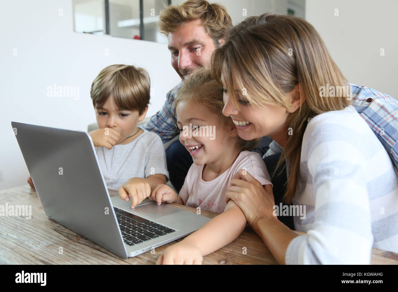 Parents with kids at home using laptop computer Stock Photo Alamy