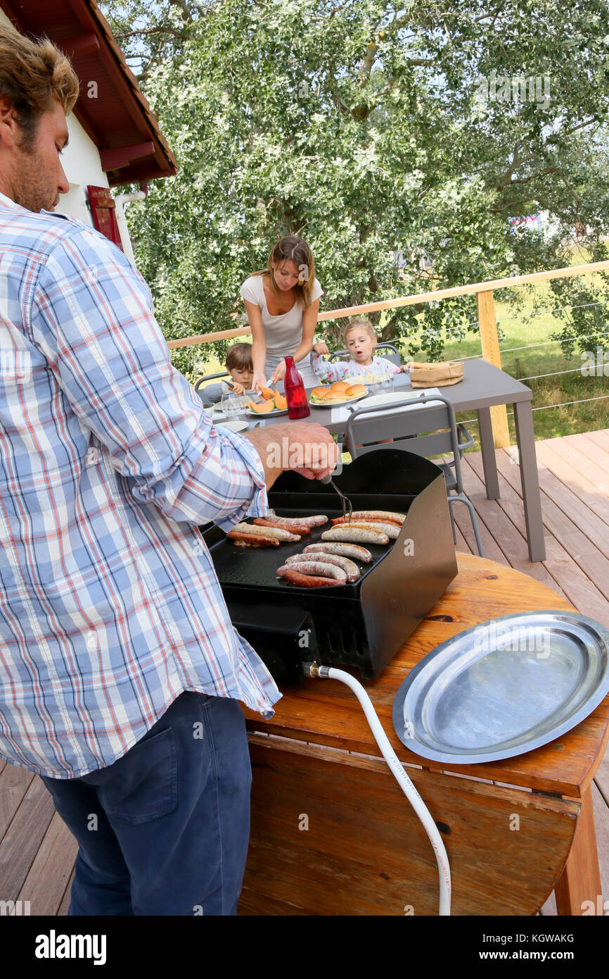 Closeup of man cooking grilled meat on barbecue Stock Photo