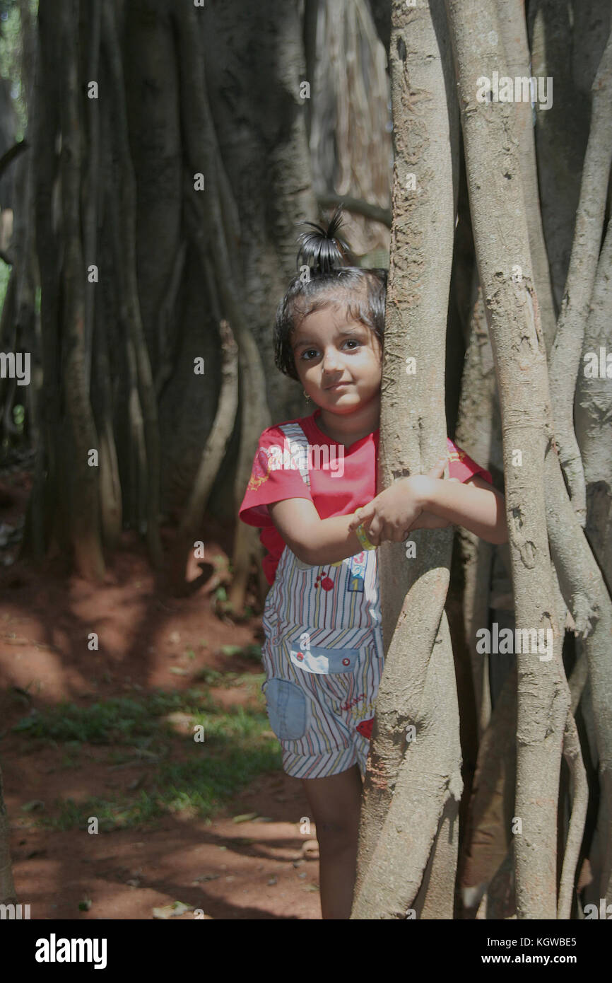 Baby In Tree Roots Little kid embracing root of Banyan tree as if to save plant life Stock ...