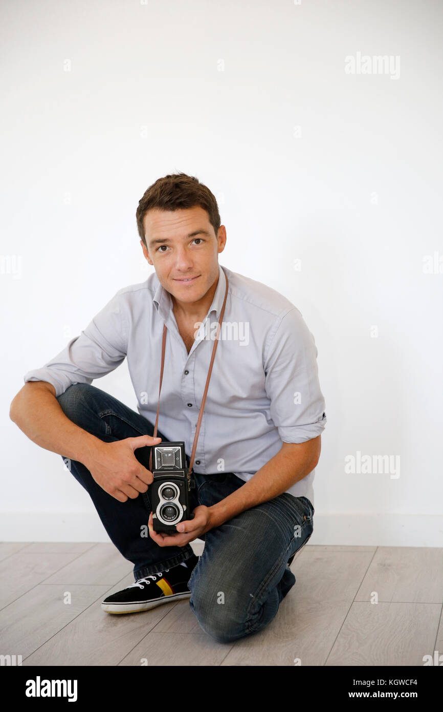 Smiling photographer holding vintage camera Stock Photo