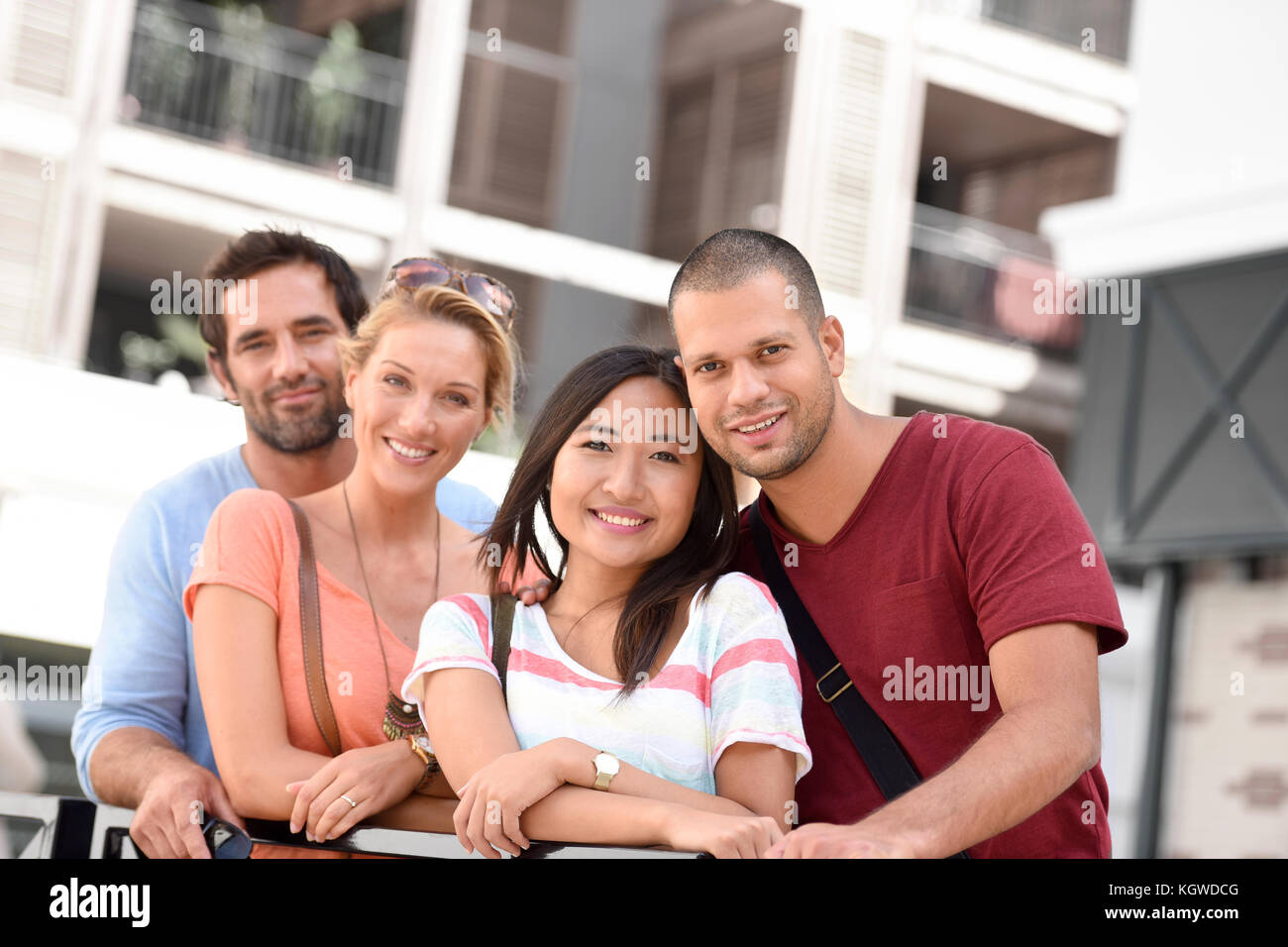 Group of young couples standing by building of apartments Stock Photo