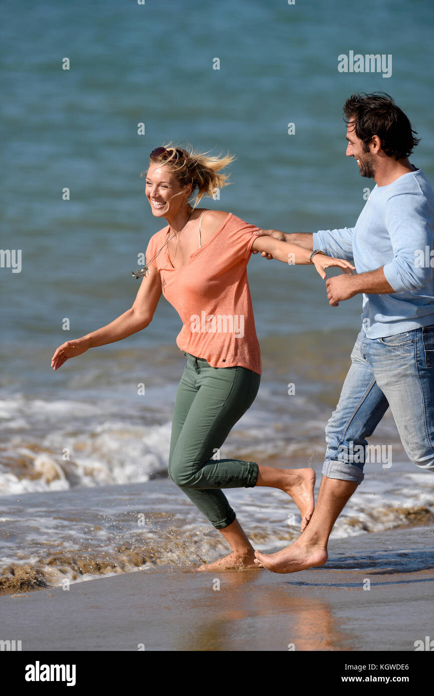 Couple running and having fun on the beach Stock Photo