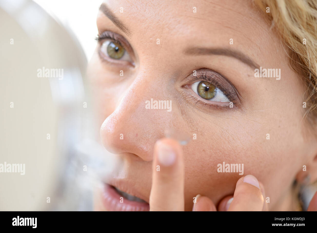 Woman putting lenses on Stock Photo