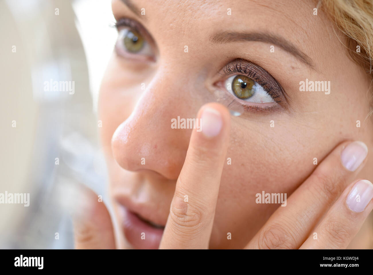 Woman putting lenses on Stock Photo