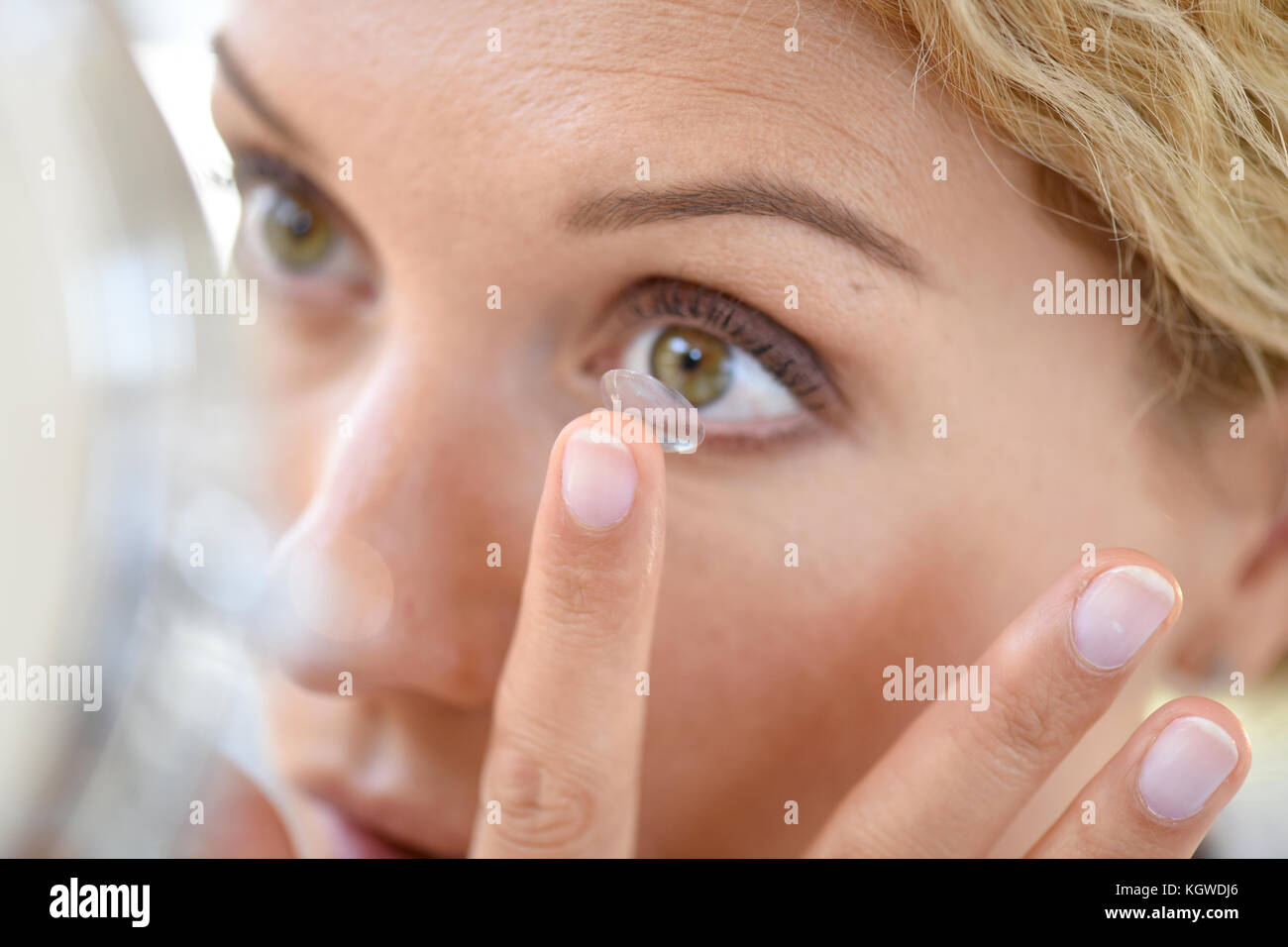 Woman putting lenses on Stock Photo