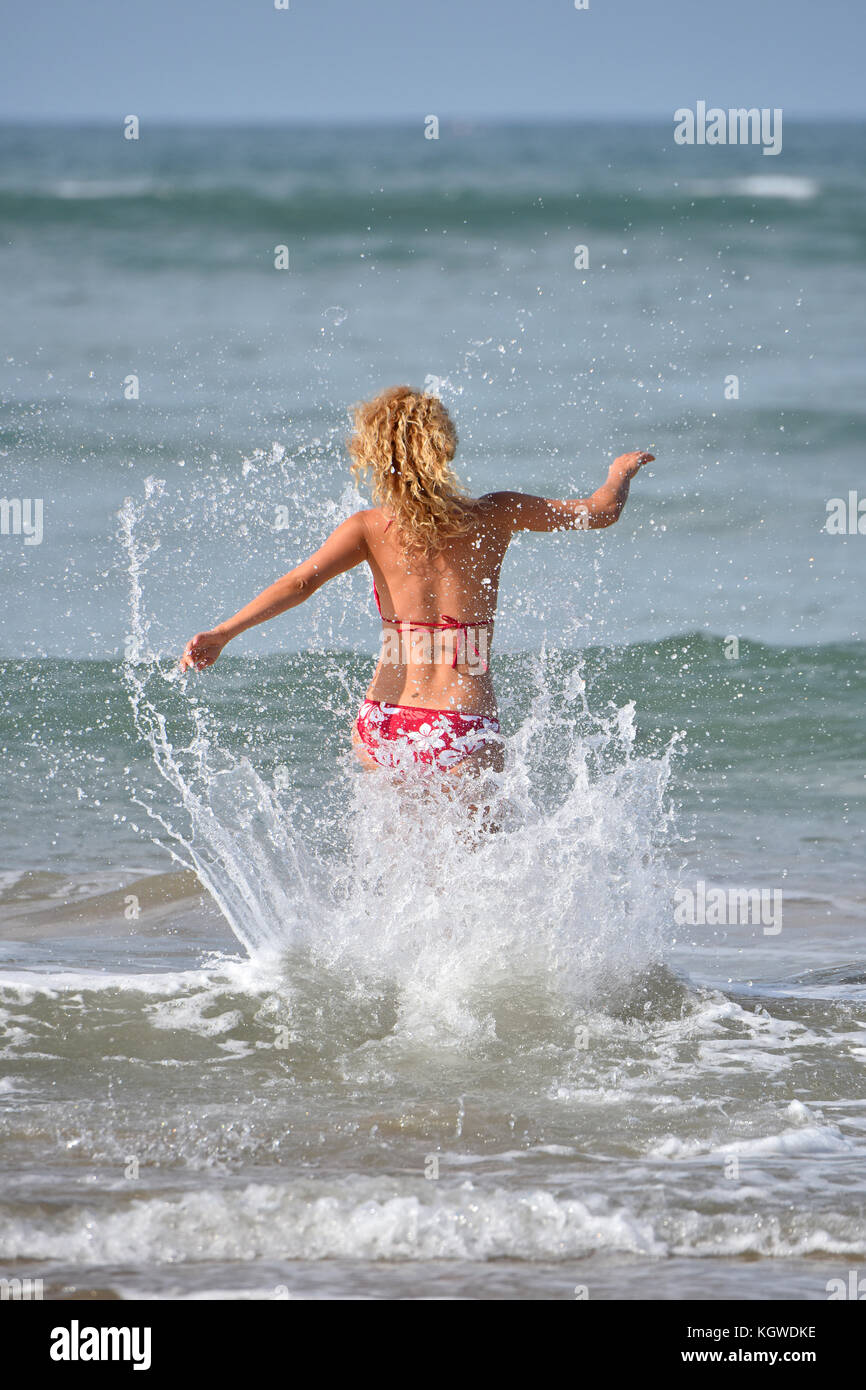 side view of woman in cap and swimming suit surfing in ocean Stock Photo -  Alamy